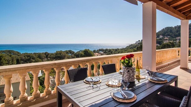 Mesa lista para comer con vista al mar y las colinas.