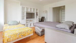 Un dormitorio con cama, escritorio, silla y armario.