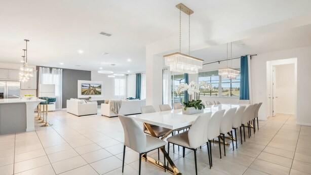 Un'ampia cucina moderna con zona pranzo, ampie finestre e vista sull'esterno.