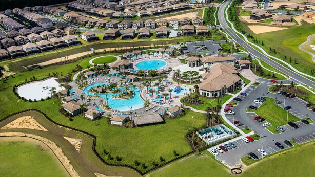 An aerial view of a residential area with a swimming pool complex, a parking lot, and a road network. - Last Minute Disney Getaway! Private Pool, Game Room & Themed Bedrooms. Book Now! #163615 (Orlando)