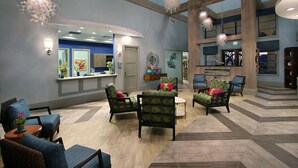 A spacious lobby with multiple seating areas, a reception desk, and a large open space with a high ceiling and wooden beams. - Last Minute Disney Getaway! Private Pool, Game Room & Themed Bedrooms. Book Now! #163615 (Orlando)