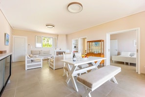 A spacious living area with a dining table, sofas, and a kitchen area. - Villa Limanaki, Villa Limanaki Lavrion Port (Lavrio)