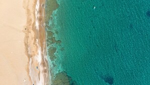An aerial view of a beach with clear turquoise waters and sandy shores. - Villa Limanaki, Villa Limanaki Lavrion Port (Lavrio)
