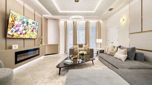 A modern living room with a flat-screen TV, a fireplace, a sofa, and a coffee table. - Last Minute Disney Getaway! Private Pool, Game Room & Themed Bedrooms. Book Now! #163621 (Orlando)