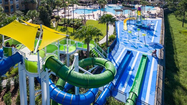 Un parc aquatique doté de nombreux toboggans et de plusieurs piscines, entouré d’immeubles.