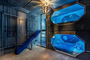 A room with a slide, hexagonal windows, and a space-themed wall. - Last Minute Disney Getaway! Private Pool, Game Room & Themed Bedrooms. Book Now! #163635 (Orlando)