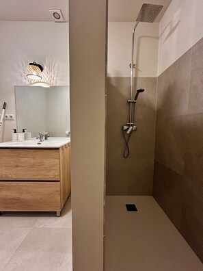 A bathroom with a shower, a sink, and a mirror. - Luxury villa with infinity pool and panoramic mountain views near Málaga (Álora)