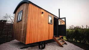 A wooden cabin with a door, windows, and a chimney. - Shepherds View (Ashbourne)