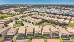 Zona residencial con varias casas, una calle curva y un horizonte urbano lejano.