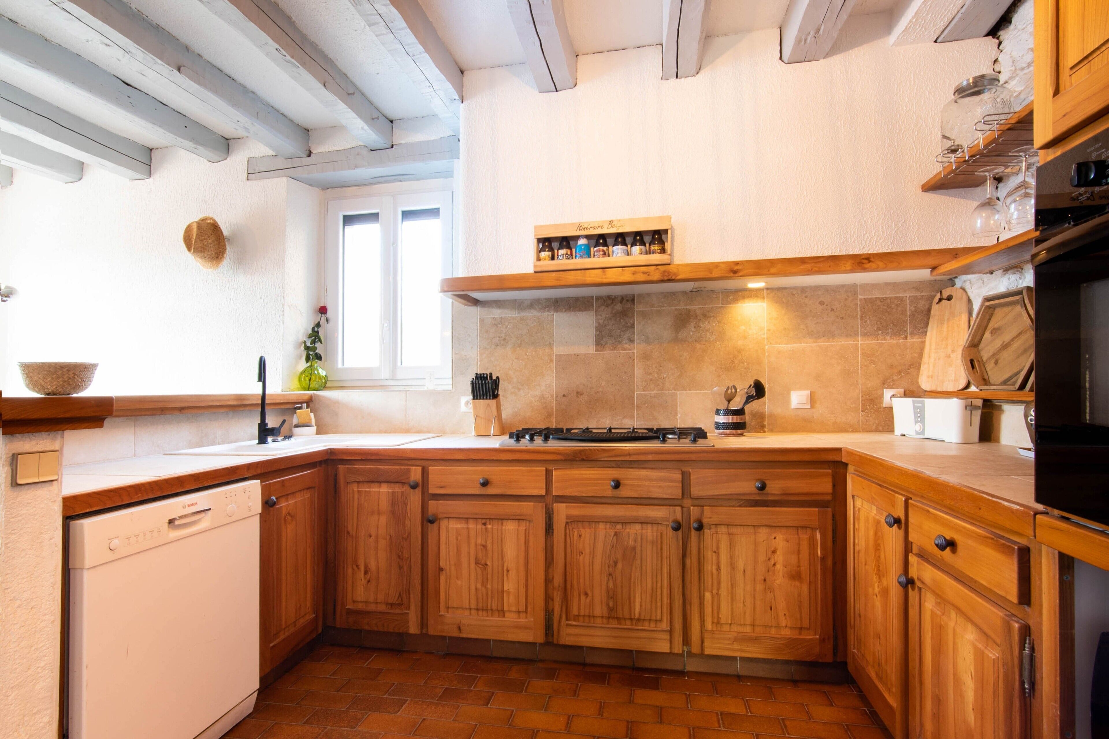 A kitchen with wooden cabinets, a built-in oven, and a window.