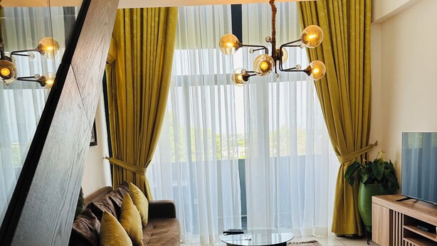 Una sala moderna con una mesa de centro de vidrio, un sofá de cuero y un mueble para televisión.