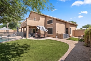 A two-story house with a patio, outdoor furniture, and a swimming pool. - Tranquil 4-Bedroom House in charming Cave Creek-Fresh Remodel (Cave Creek)