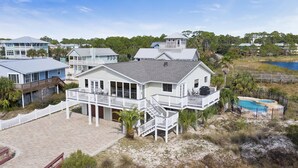 Une propriété située en bord de mer, comprenant une grande maison, une piscine et un espace de plage.