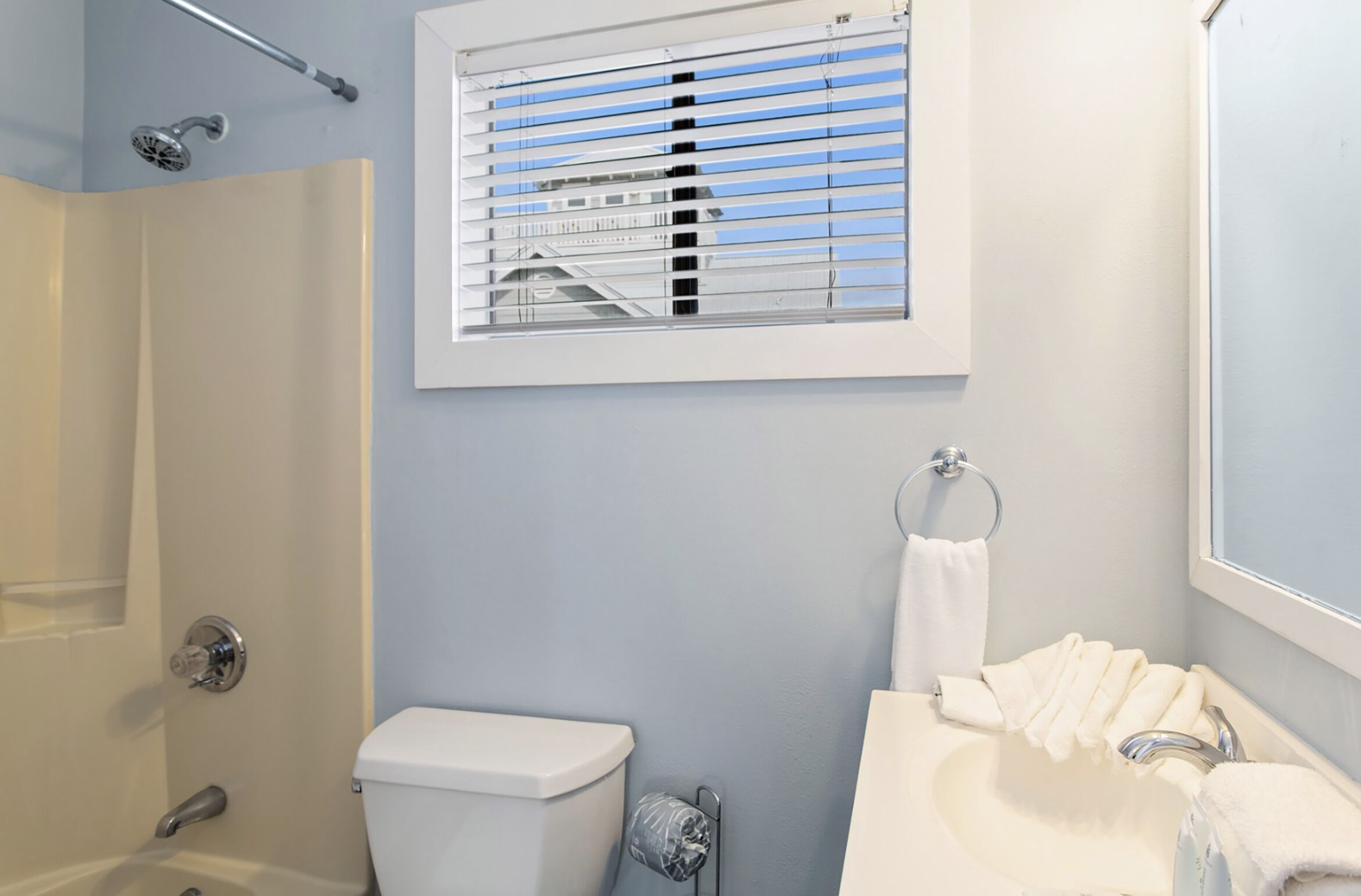 A bathroom with a toilet, sink, and shower.