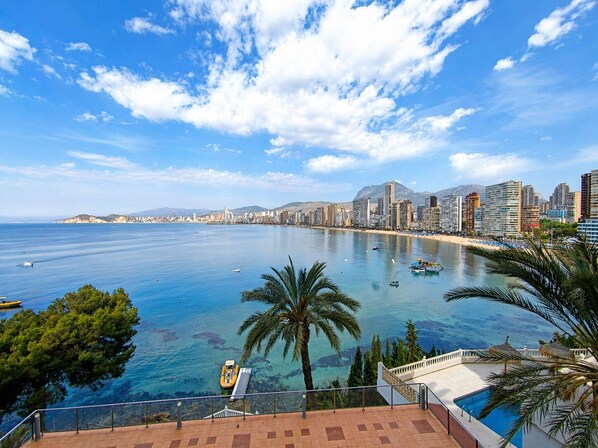 A coastal cityscape with a clear blue sea, a sandy beach, and a city skyline with modern buildings. - Hotel Bossh Lido (Benidorm)
