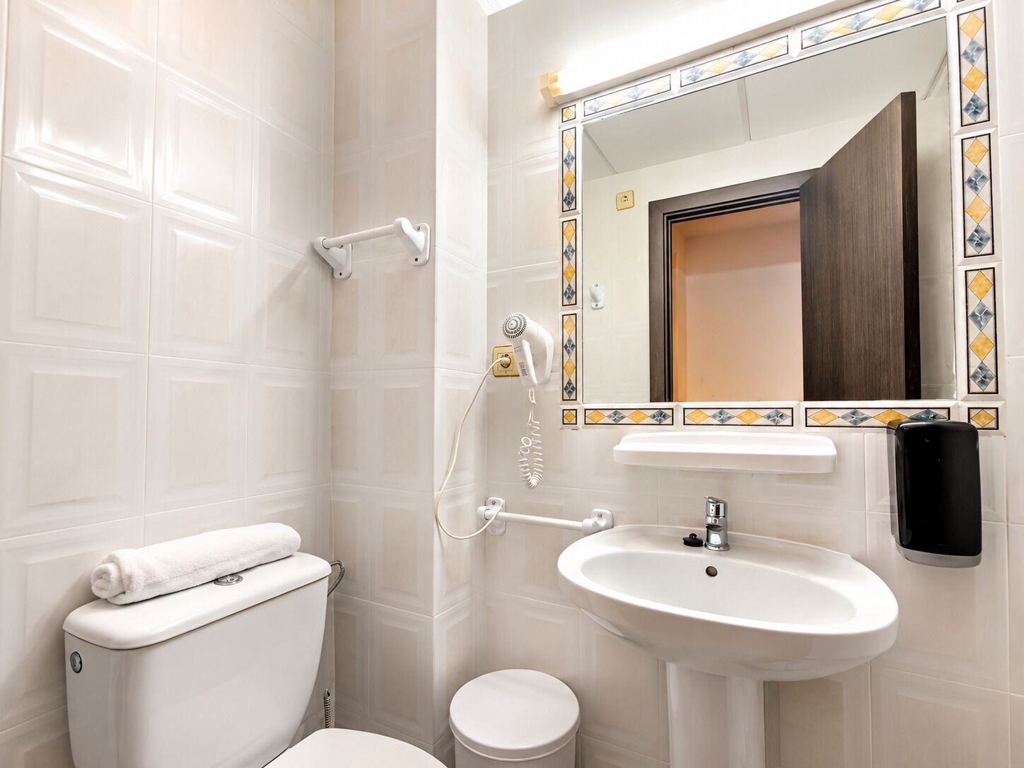 A bathroom with a toilet, sink, and shower.