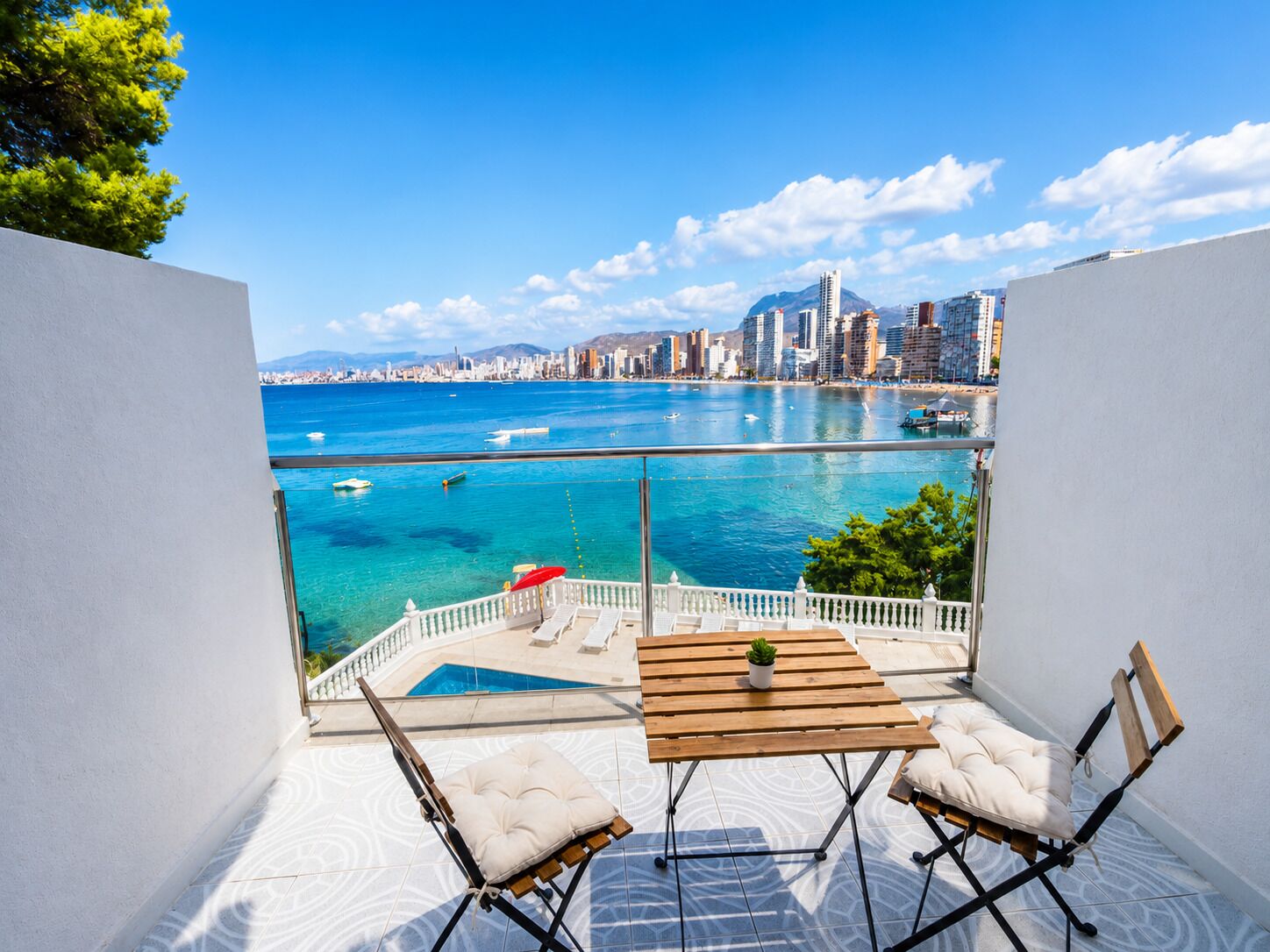 A balcony with a view of a city skyline and a body of water.