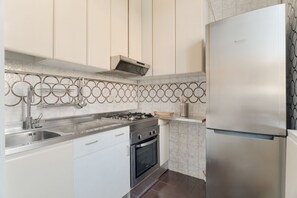 Eine moderne Küche mit Edelstahlgeräten, einem Gasherd, einem Backofen und einer eingebauten Spüle.
