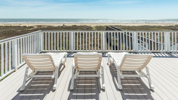 A deck with three white lounge chairs facing a beach. - Beachfront Home w/ Great Views, Private Walkover & Dog Friendly! (Galveston)
