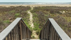 A wooden boardwalk leading to a beach with dunes and sparse vegetation. - Beachfront Home w/ Great Views, Private Walkover & Dog Friendly! (Galveston)