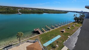 Une vue sur le fleuve, avec un quai, un sentier pédestre et une zone herbeuse agrémentée d’un pavillon.