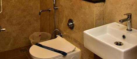A bathroom with a toilet, a sink, and a shower.