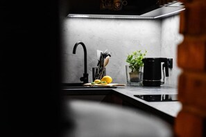 A kitchen with a modern faucet, a coffee maker, and a potted plant. - Holiday Home, Bedroom With Bathtub, Jacuzzi (Koscierzyna)