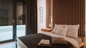 A bedroom with a bed, a bedside table, a lamp, and a view through a window. - Holiday Home, Bedroom With Bathtub, Jacuzzi (Koscierzyna)