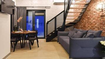 Ein moderner Wohnraum mit Treppe, Essbereich und Sitzgelegenheit.