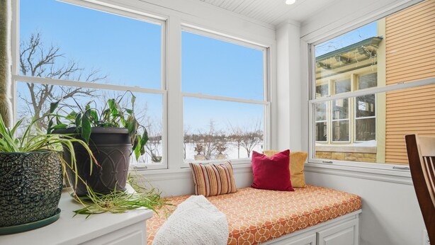 A room with a built-in bench, large windows, and potted plants. - MINNeSTAY* Como Classic (St. Paul)