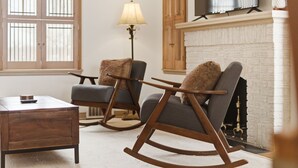 A living room with a fireplace, two rocking chairs, a coffee table, and a lamp. - MINNeSTAY* Como Classic (St. Paul)