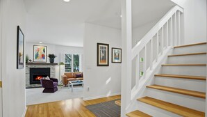 Un intérieur moderne comprenant un escalier, une cheminée et un espace de vie avec un canapé et une table basse.