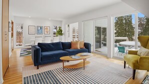 Un salon moderne avec un canapé bleu, une table basse en bois et un fauteuil jaune.