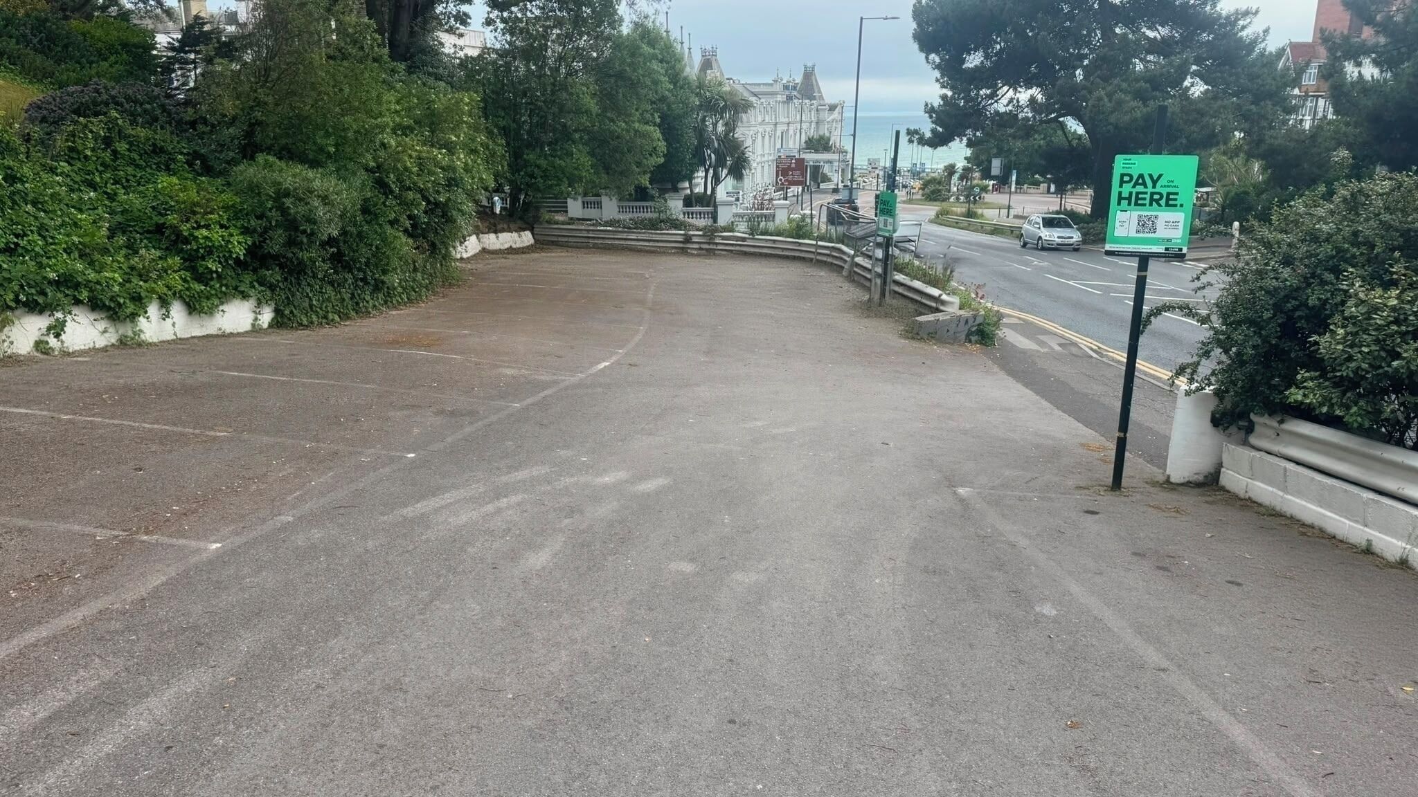 Un estacionamiento con un letrero verde que indica que se requiere pago.