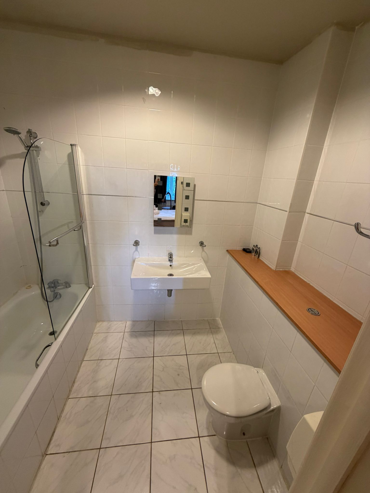 Une salle de bain avec une douche à parois de verre, un lavabo et des toilettes.