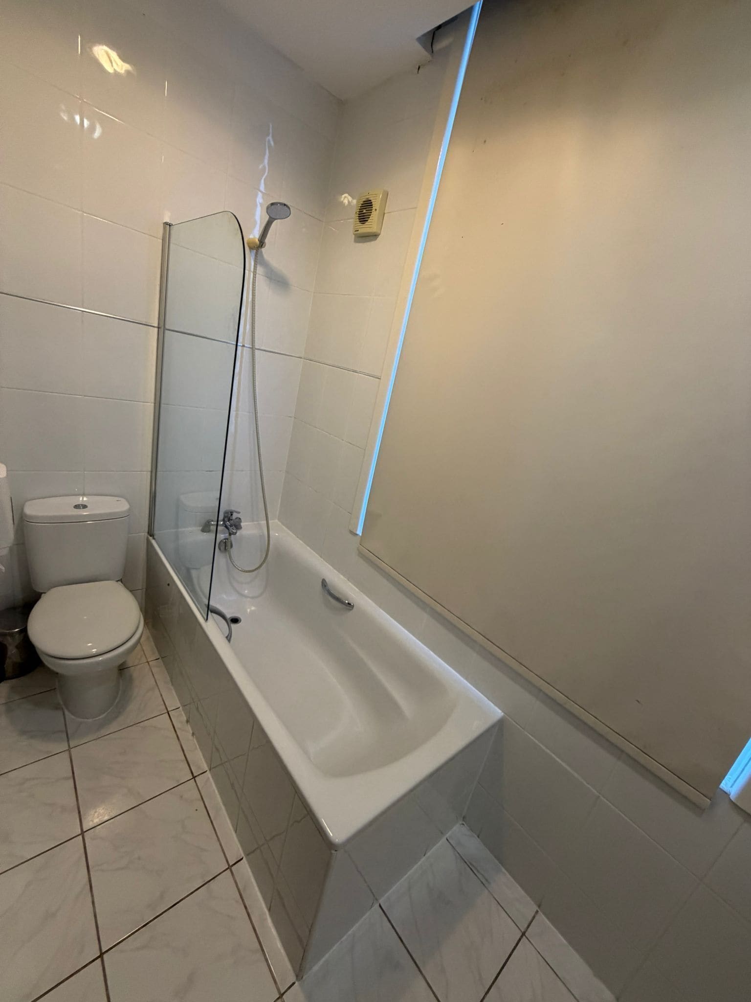 Un baño con bañera, inodoro y cabina de ducha de vidrio.