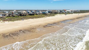 Ein Strand mit Holzkonstruktionen, Sand und Wellen.