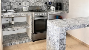 A compact kitchen with a gas stove, oven, and a sink. - Relax in paradise (Playa del Carmen)