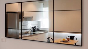 Eine moderne Küche mit einem Edelstahlkühlschrank, einer Spüle und einem Essbereich mit Tisch und Stühlen.
