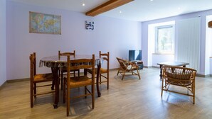 Un espace repas avec des meubles en bois, une carte accrochée au mur et une fenêtre laissant entrer la lumière naturelle.
