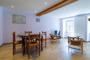 Zona pranzo con mobili in legno, una mappa appesa al muro e una finestra che illumina con luce naturale.