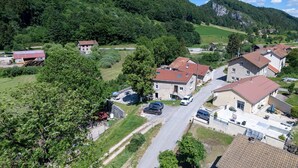A residential area with houses, a road, and a forested hill in the background. - Apartment 'Dans Hameau Du Vercors' with Shared Terrace and Wi-Fi (Saint-Agnan-en-Vercors)