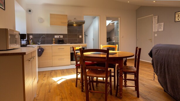 A modern kitchen with a dining area, wooden flooring, and a skylight. - Apartment 'Dans Hameau Du Vercors' with Shared Terrace and Wi-Fi (Saint-Agnan-en-Vercors)