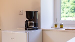 A coffee maker on a white appliance, a window with a view, and two condiment containers on a windowsill. - Apartment 'Dans Hameau Du Vercors' with Shared Terrace and Wi-Fi (Saint-Agnan-en-Vercors)
