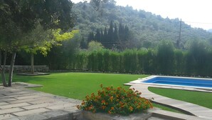 A landscaped garden with a swimming pool, stone steps, and a flower bed. - Villa 'Can Bandris' with Mountain View, Wi-Fi and Air Conditioning (Illes Balears)