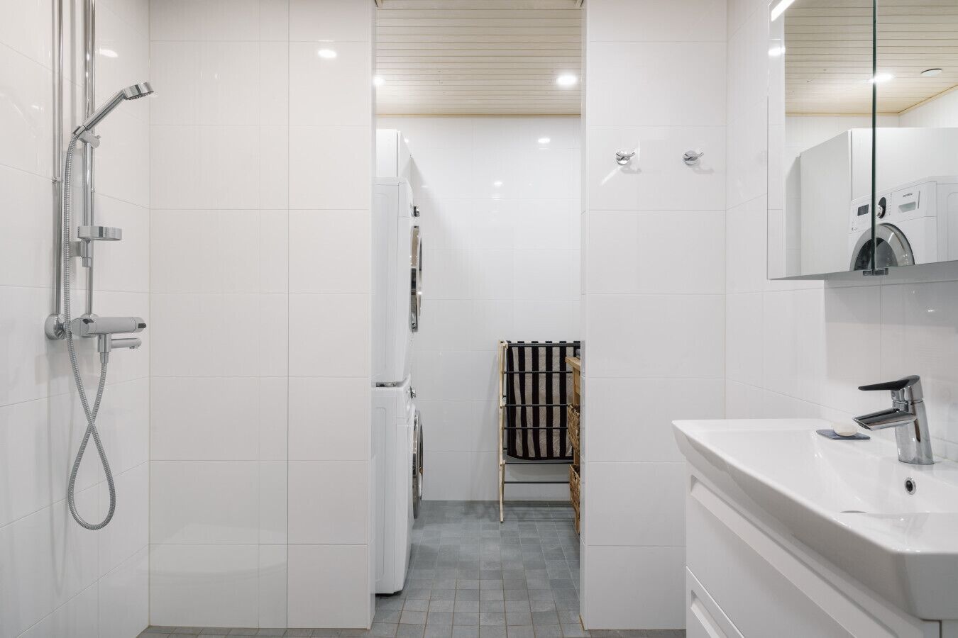 Een moderne badkamer met een douche, toilet en wastafel.