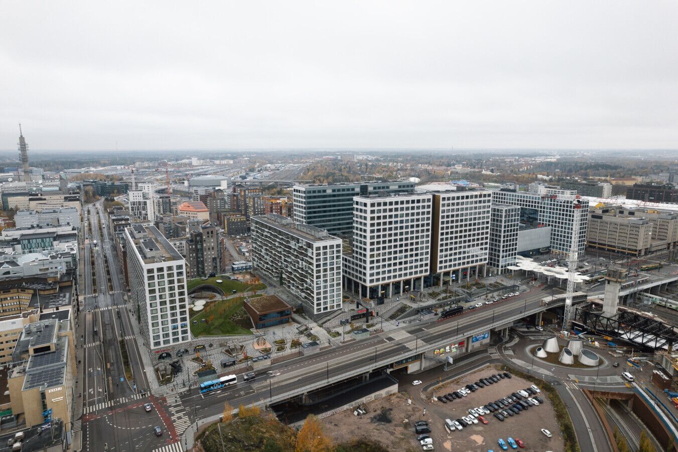 A high-rise building with a modern architectural design, surrounded by a busy urban environment with roads and other buildings.