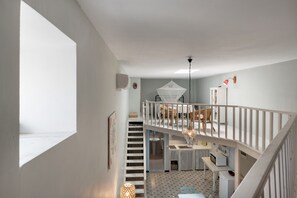 Un intérieur à plusieurs niveaux comprenant un escalier, un coin repas et une cuisine.