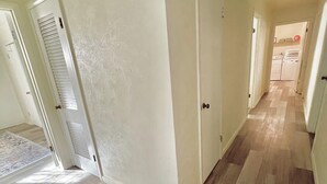 A hallway with wooden flooring, white walls, and doors leading to other rooms. - 🏡 Spacious Stay on Bridge – 4BR / 2BA<br><br>Comfortable 4-bedroom, 2-bath home perfect for families or groups, with bright living areas, a full kitchen, and a convenient Abilene location. 🌟 (Abilene)