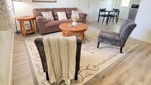 A living room with a brown sofa, a round coffee table, a patterned armchair, and a dining area in the background. - 🏡 Abilene Restful Retreat – 2BR / 2BA ✨<br>Enjoy a cozy and relaxing stay in Abilene. This comfortable home is perfect for families, friends, or business travelers and is conveniently located near restaurants, shopping, and local attractions. 🌟 (Abilene)